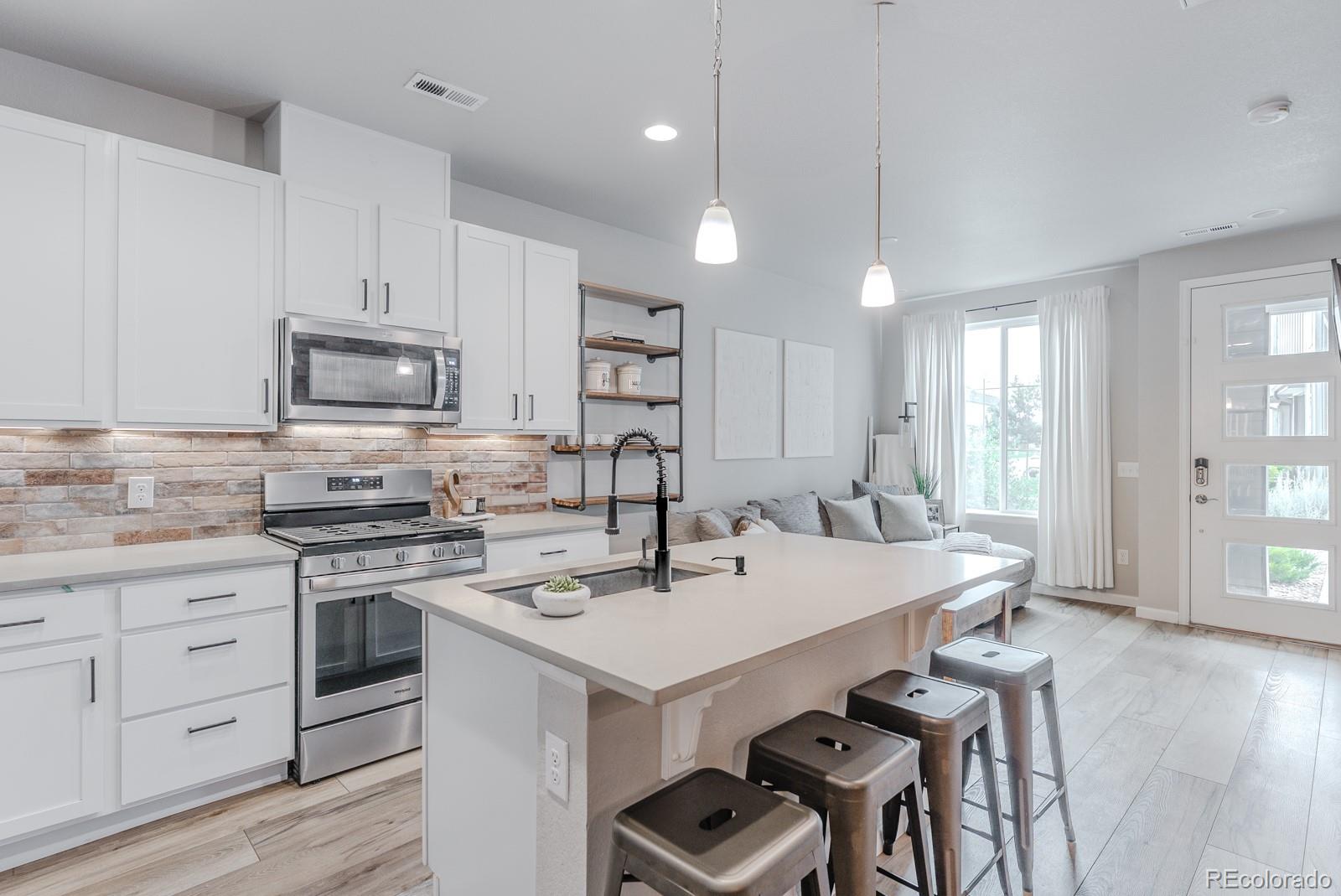 a kitchen with a stove a sink and a refrigerator
