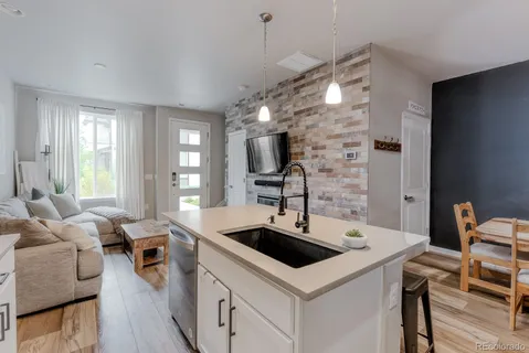 a kitchen with a sink a counter space and living room