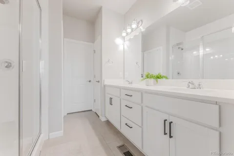 a bathroom with double vanity sink and a mirror