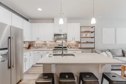 a kitchen with stainless steel appliances a sink a stove a refrigerator and cabinets