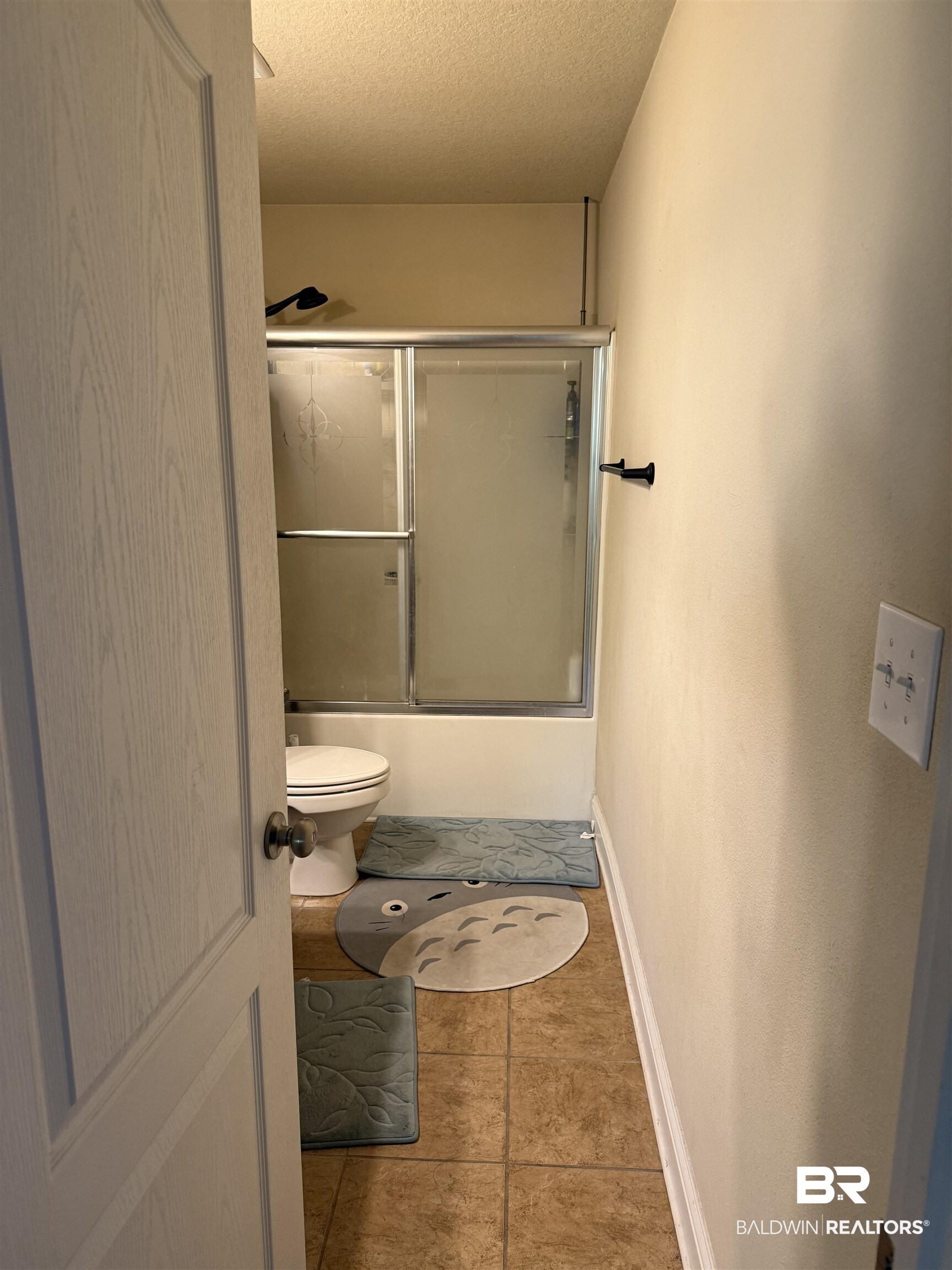 9023 Krystal Ridge Court Daphne, AL 36526 - Photo 24 of 41 Bathroom featuring combined bath / shower with glass door, a textured ceiling, and tile patterned flooring