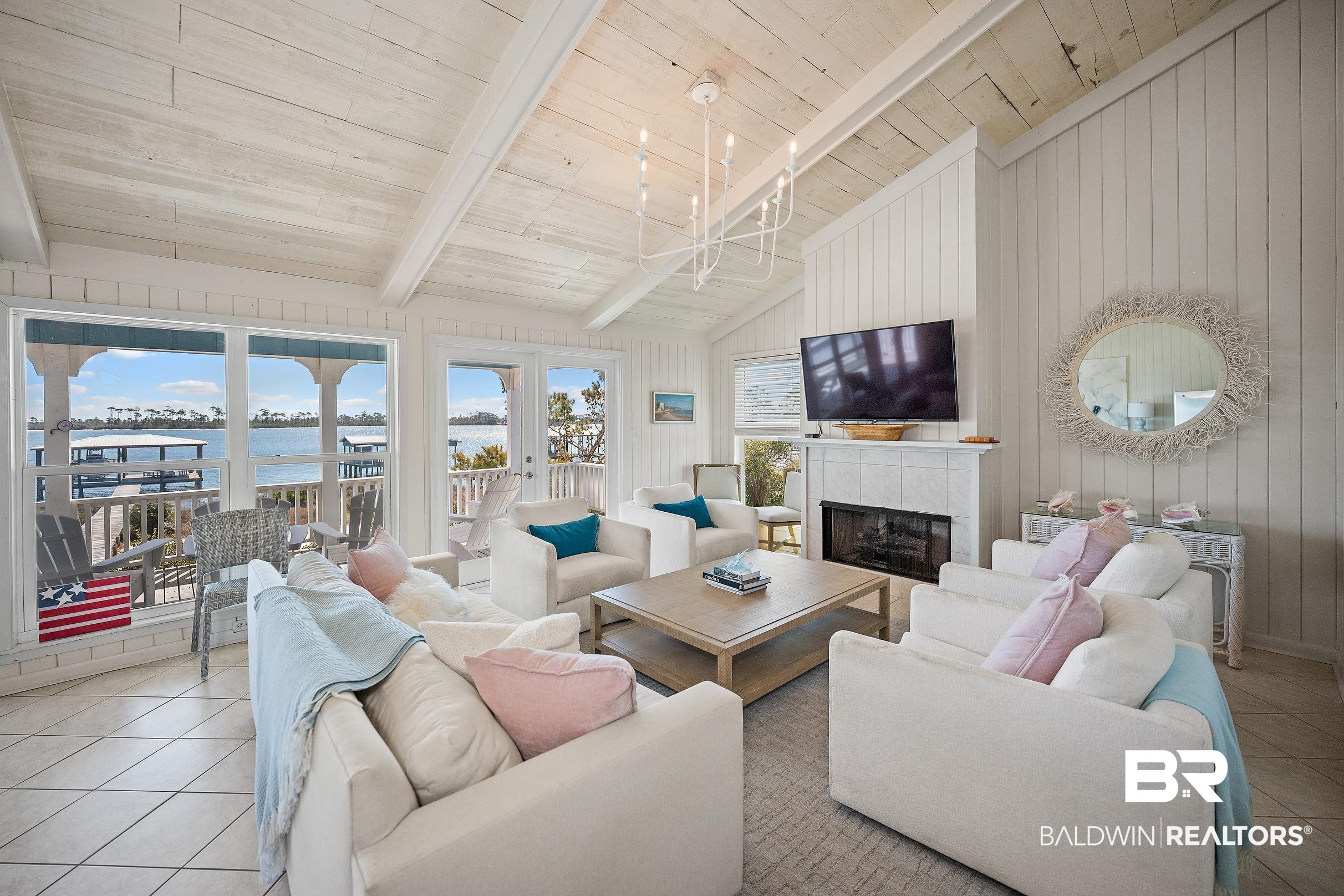 32620 River Road Orange Beach, AL 36561 - Photo 10 of 60 Tiled living area with wooden walls, a tiled fireplace, wood ceiling, lofted ceiling with beams, and french doors