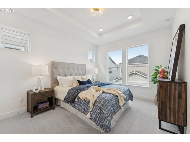 a bedroom with a bed and a flat tv screen on dresser