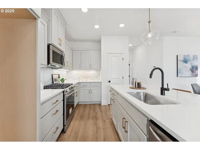 a kitchen with white cabinets appliances and sink