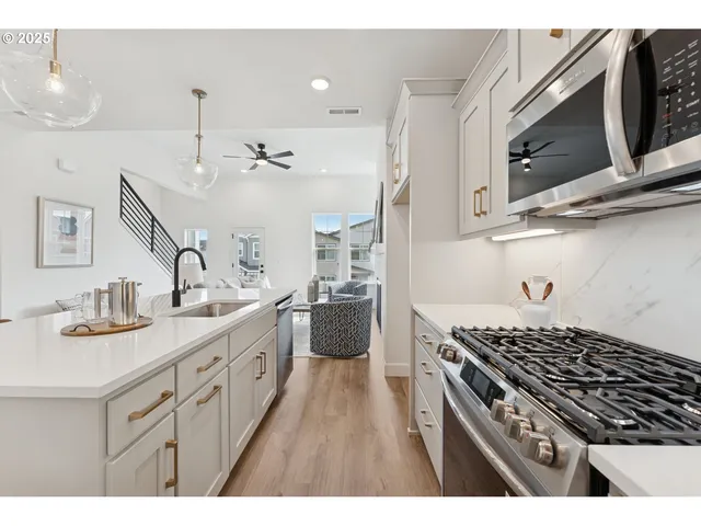 a kitchen with stainless steel appliances a sink stove and cabinets