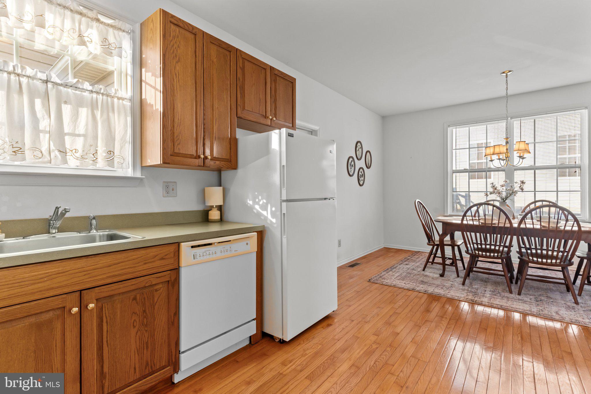 237 Beaumont Drive Oxford, PA 19363 - Photo 13 of 46 a kitchen with stainless steel appliances granite countertop a refrigerator a stove a sink dishwasher with a dining table and chairs