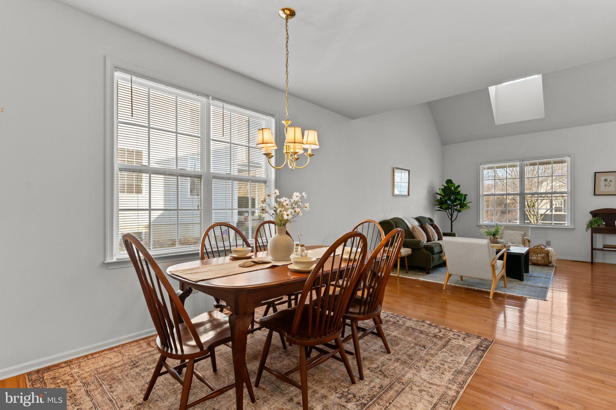 237 Beaumont Drive Oxford, PA 19363 - Photo 10 of 46 a view of a dining room and livingroom with furniture wooden floor a rug a potted plant and a chandelier
