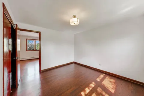 a view of a room with wooden floor and a window
