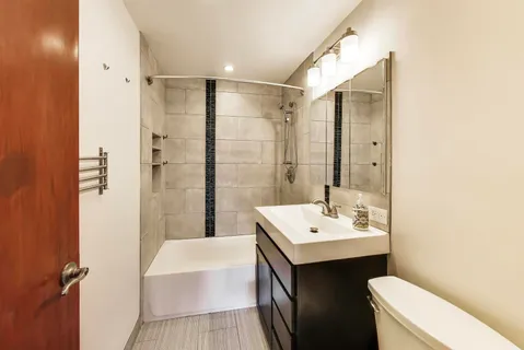 a bathroom with a sink a toilet a mirror and shower