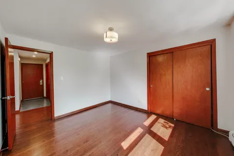 an empty room with wooden floor and closet