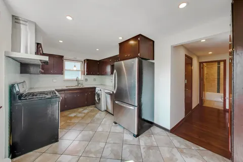 a kitchen with stainless steel appliances granite countertop a refrigerator a sink and a stove