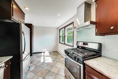 a kitchen with stainless steel appliances granite countertop a stove a refrigerator and a cabinets