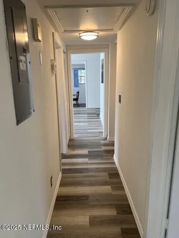 a view of a hallway with wooden floor and entryway