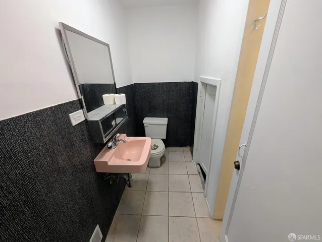 a bathroom with a toilet and a mirror
