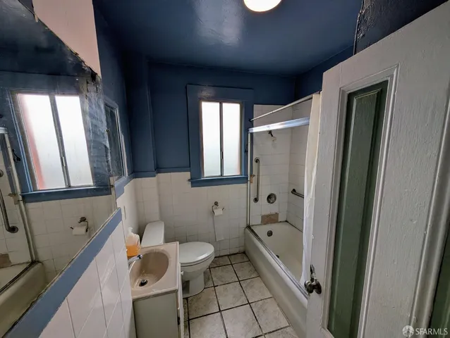 a bathroom with a bathtub shower sink mirror and toilet
