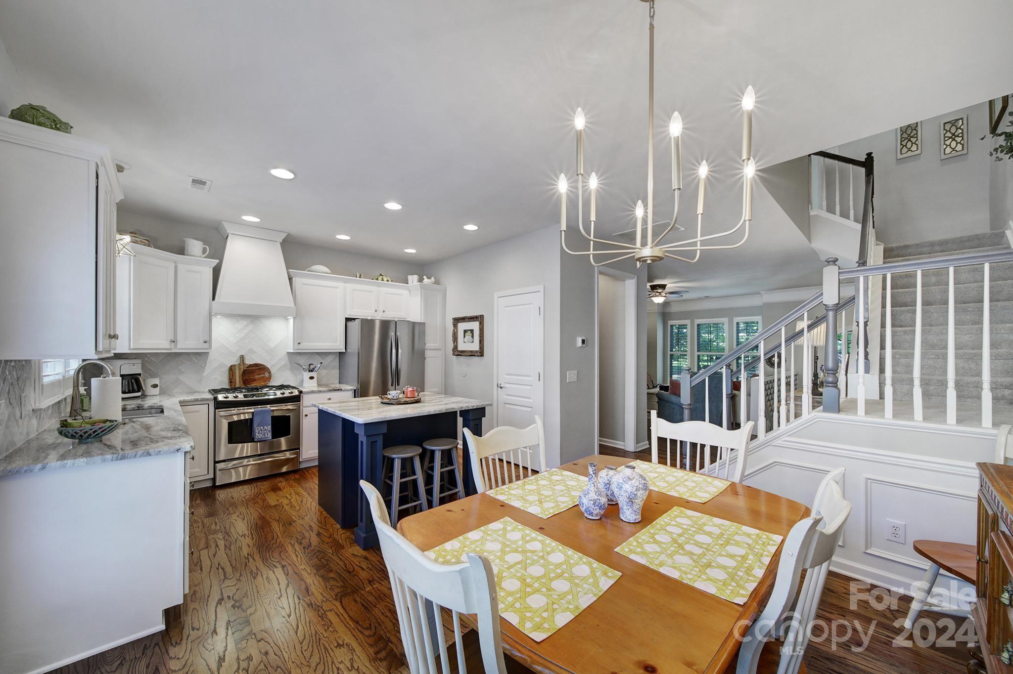 726 Passage Drive Fort Mill, SC 29708 - Photo 11 of 43 a view of a dining room and livingroom with furniture wooden floor a rug a fireplace and a chandelier