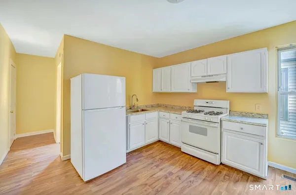 a kitchen with white cabinets and white appliances
