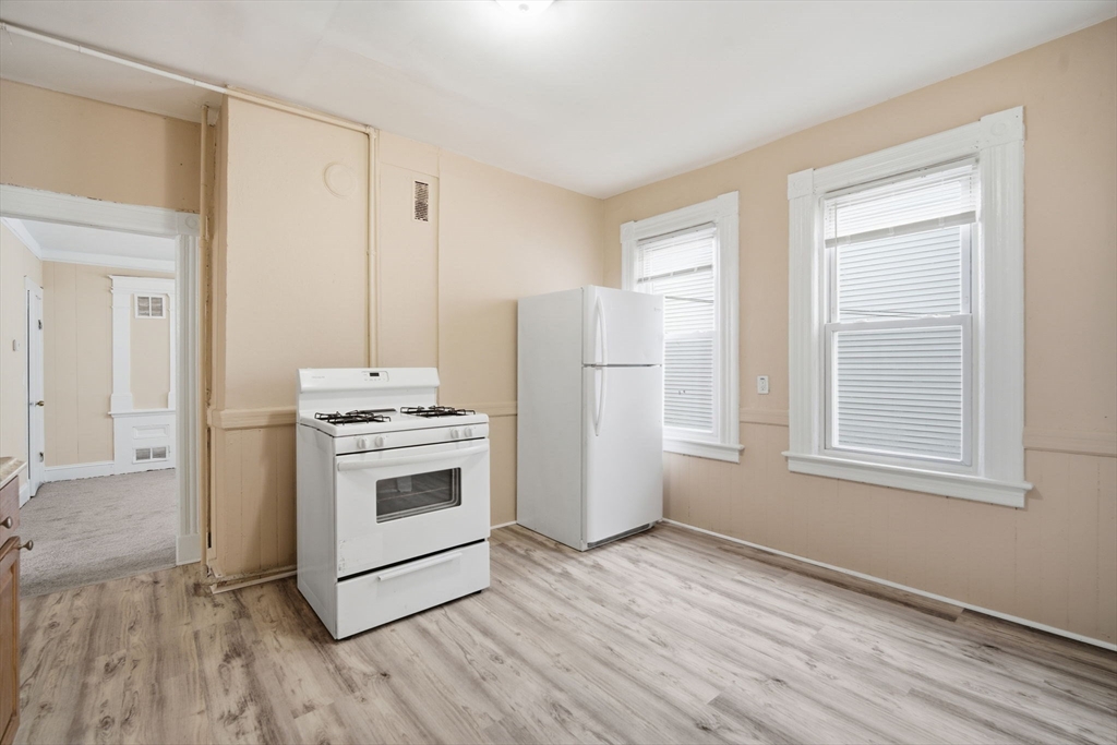 201 Main Street Springfield, MA 01108 - Photo 8 of 25 a kitchen with a hard wood floor white cabinets and a window
