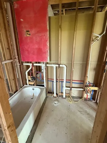 a bathroom with a tub a sink and a mirror