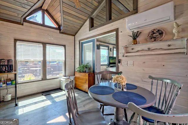 a view of a hallway to a livingroom with wooden floor and furniture