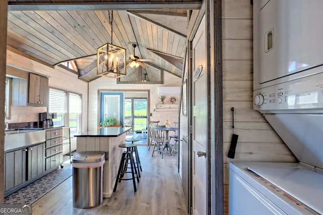 a kitchen with stainless steel appliances granite countertop a refrigerator a stove a sink dishwasher and white cabinets with wooden floor