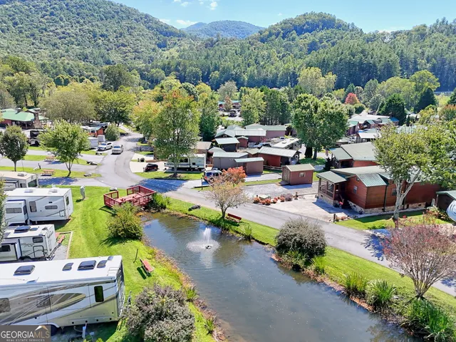 an aerial view of residential houses with outdoor space and trees