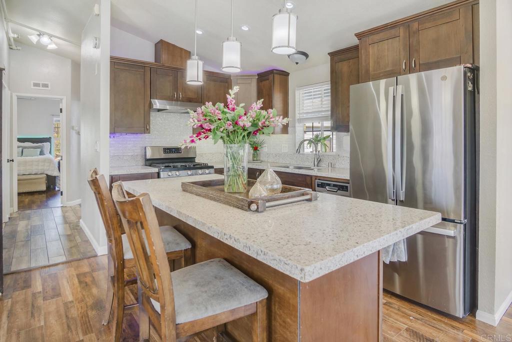 3465 Barrett View Road Alpine, CA 91901 - Photo 9 of 36 a kitchen with stainless steel appliances granite countertop a table chairs and a refrigerator