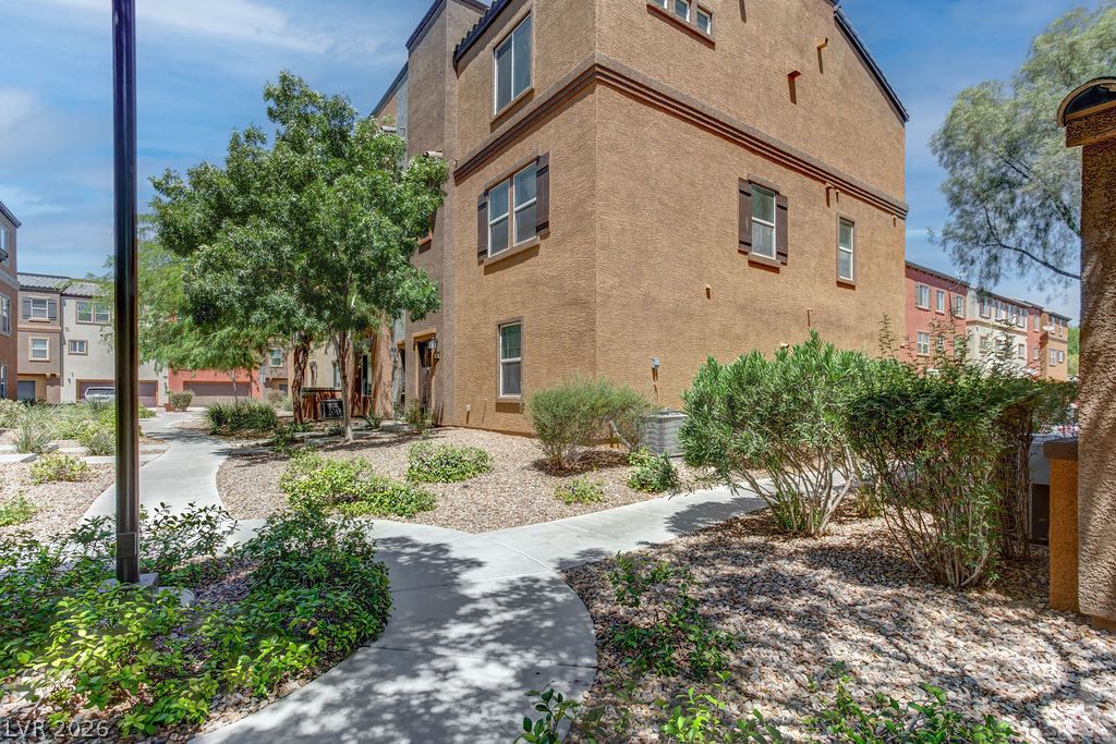 4650 Ranch House Road, Unit 47 North Las Vegas, NV 89031 - Photo 40 of 43 Discover a charming residential complex with well-maintained landscaping and inviting walkways under a bright sky.