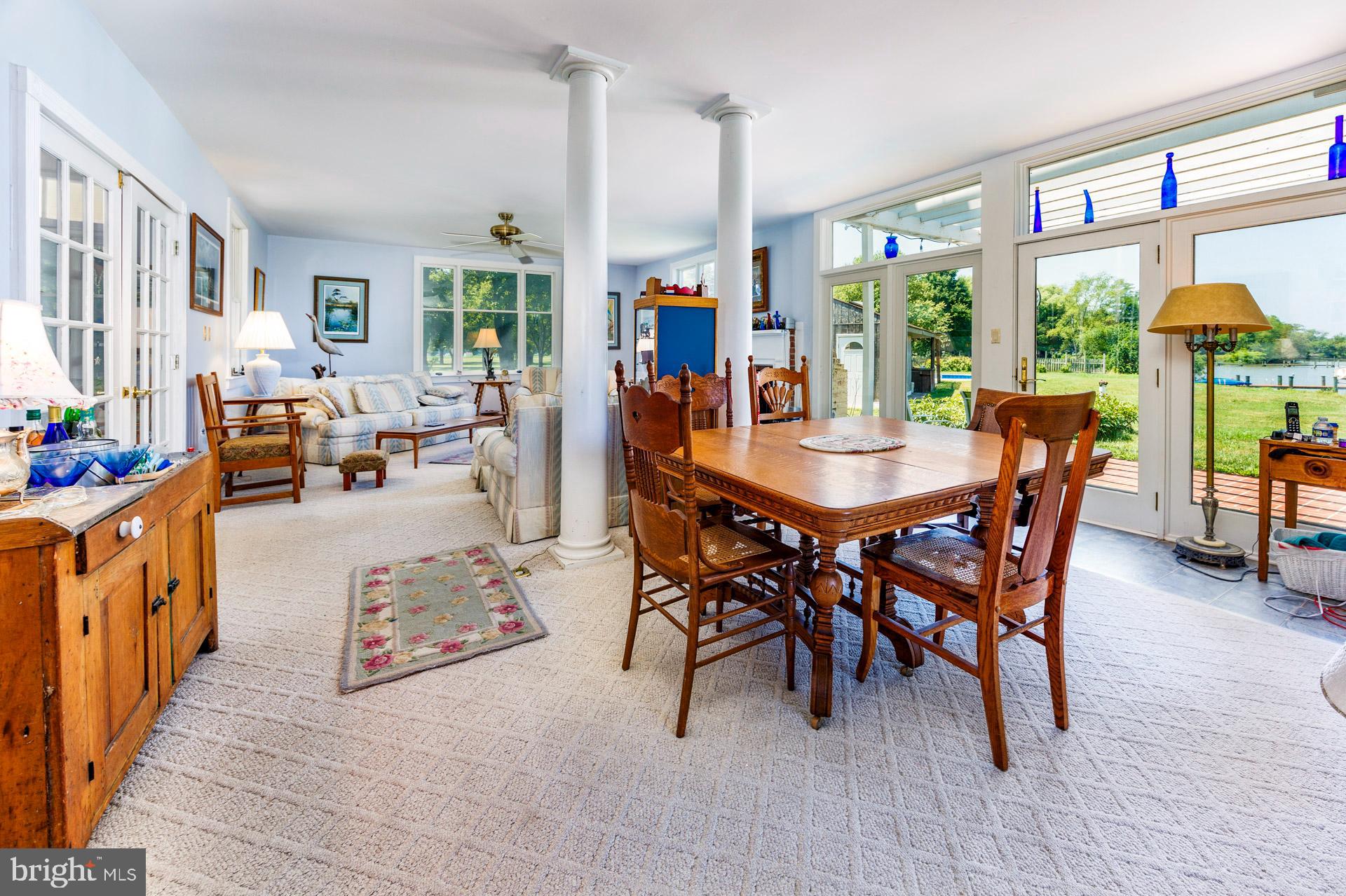 2208 Horns Point Road Cambridge, MD 21613 - Photo 24 of 61 a dining room with furniture large windows and a chandelier