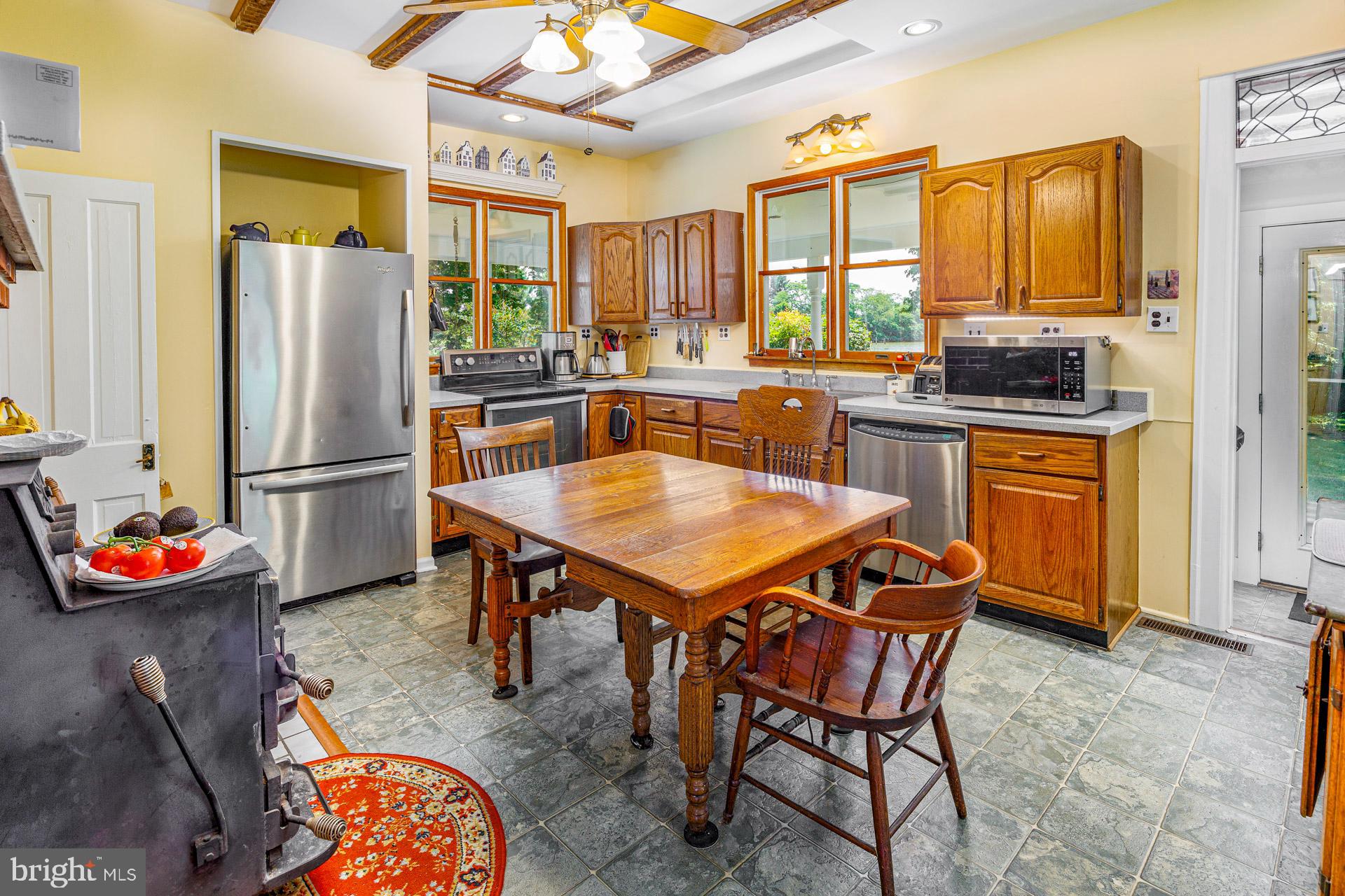 2208 Horns Point Road Cambridge, MD 21613 - Photo 29 of 61 a kitchen with stainless steel appliances granite countertop dining table chairs and a refrigerator