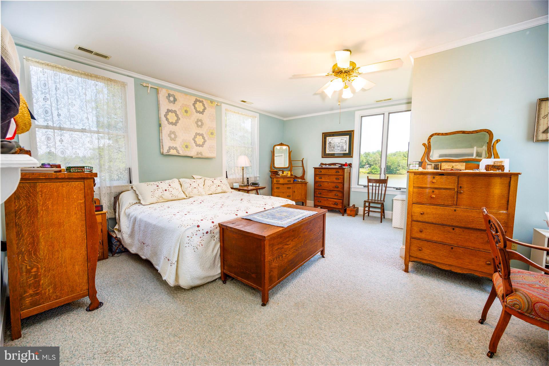 2208 Horns Point Road Cambridge, MD 21613 - Photo 38 of 61 a bedroom with a bed and wooden cabinets