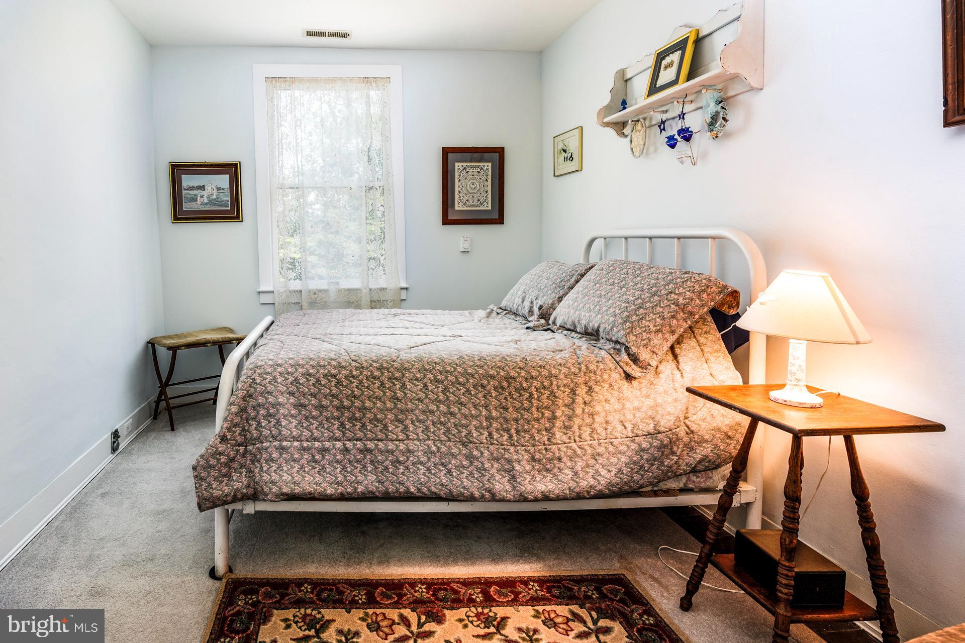 2208 Horns Point Road Cambridge, MD 21613 - Photo 49 of 61 a bedroom with a bed and a lamp