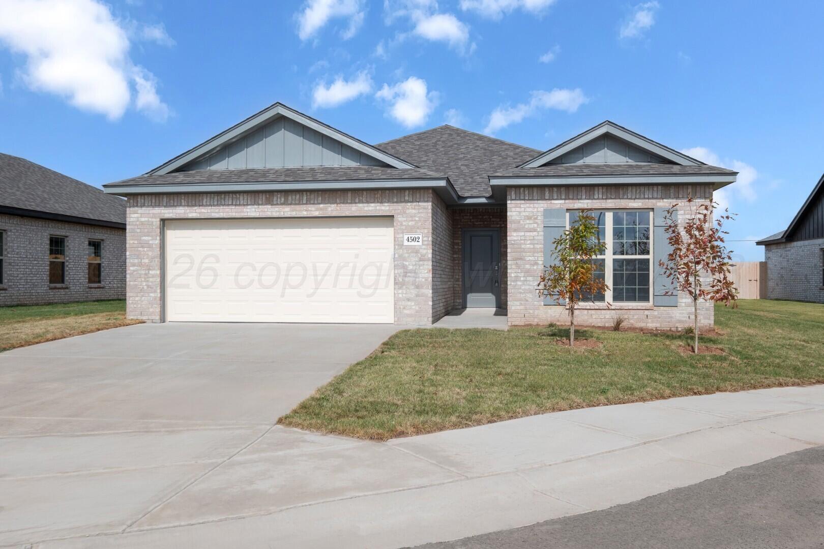 a front view of a house with a garden and yard