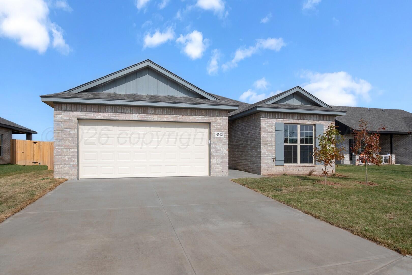10311 Ruse Street Amarillo, TX 79118 - Photo 2 of 29 a front view of a house with a yard and garage