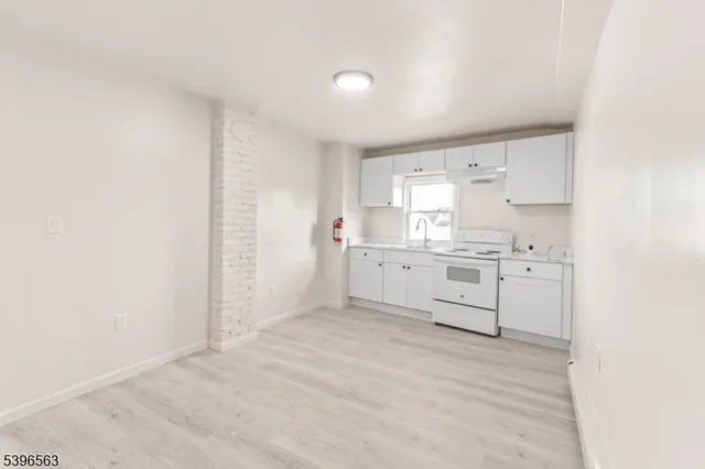 a view of a kitchen with white cabinets