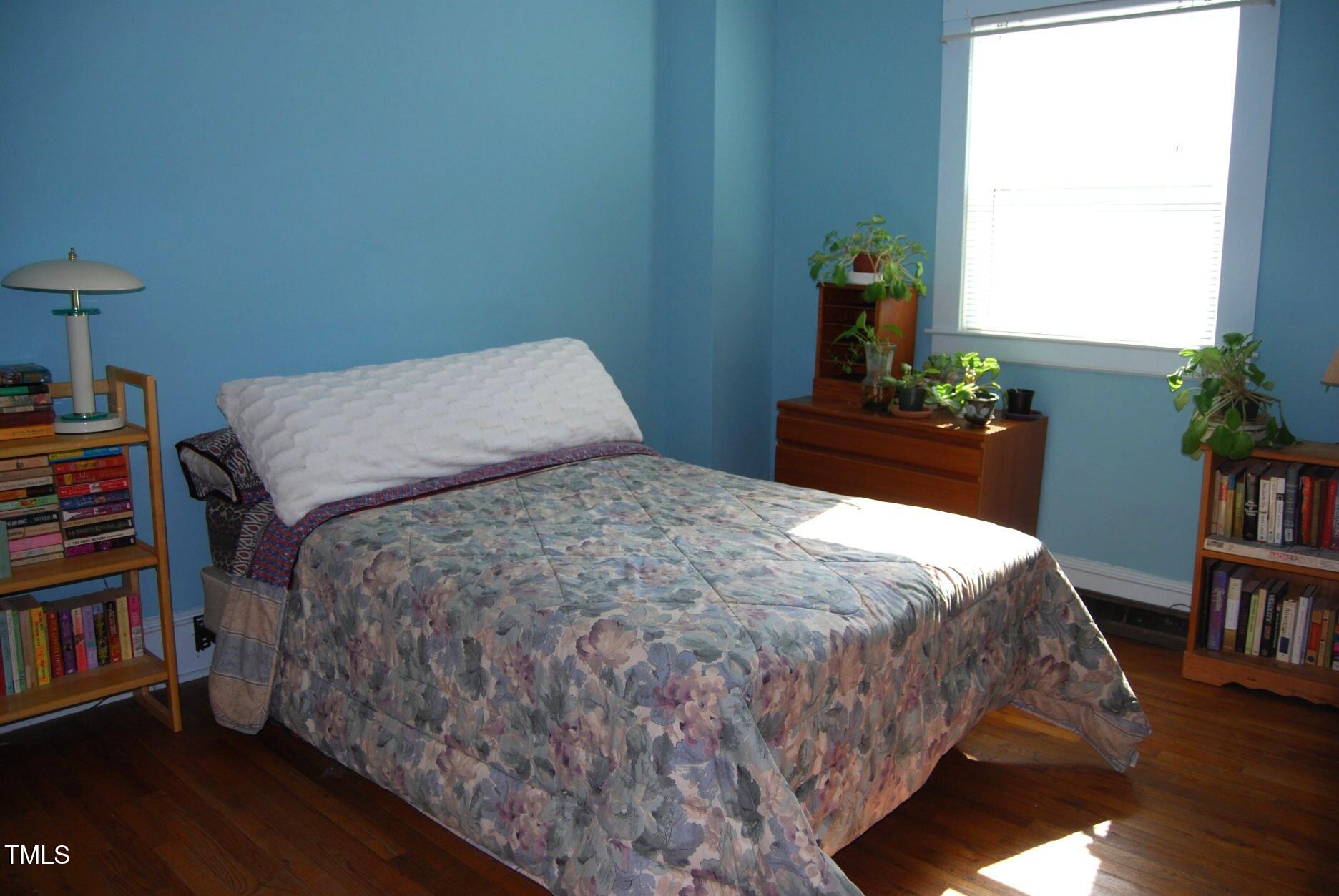 1013 Green Street Durham, NC 27701 - Photo 15 of 32 a bedroom with a bed table and a book shelf