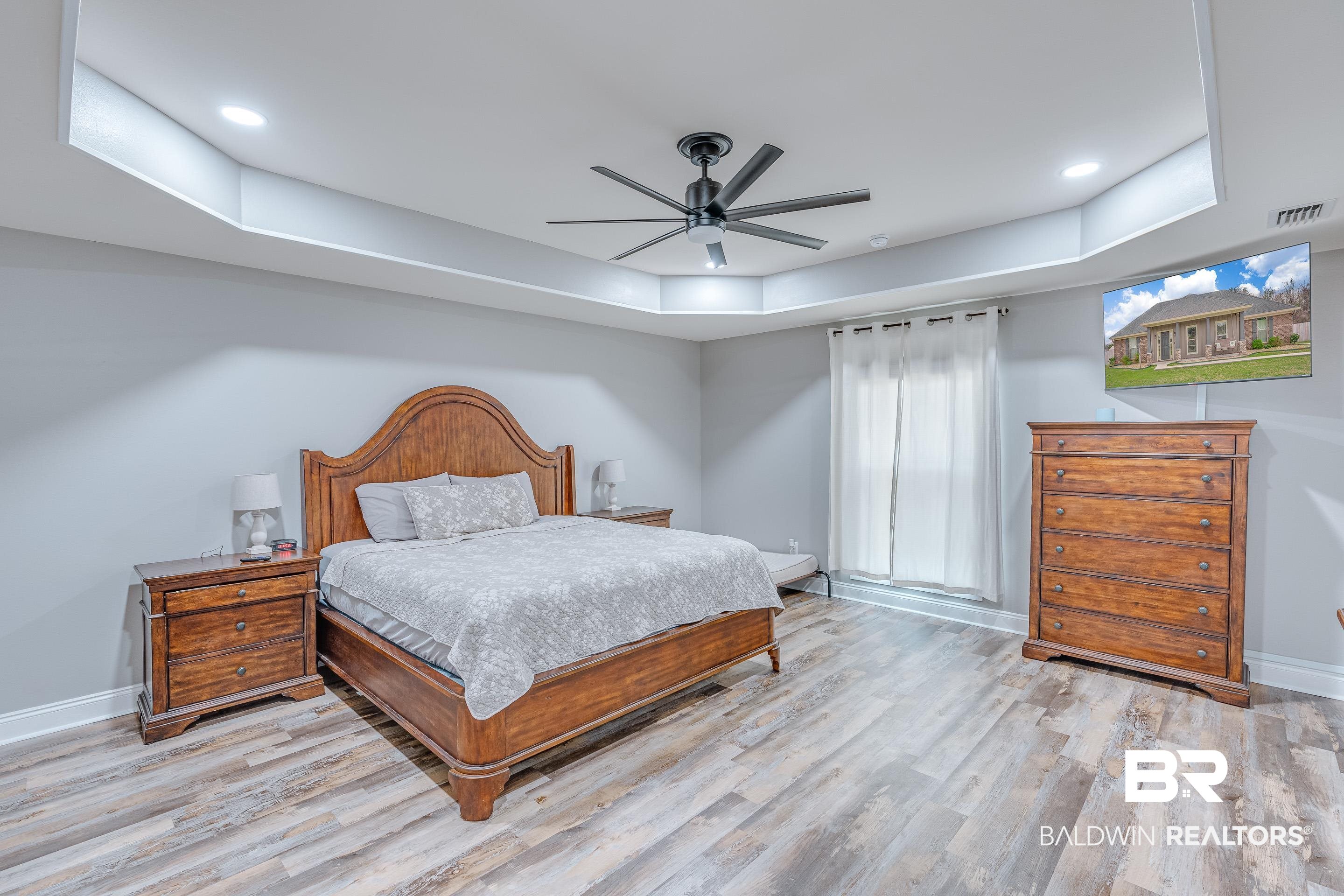 13235 Tom Gaston Road Mobile, AL 36695 - Photo 17 of 43 Bedroom with ceiling fan, a raised ceiling, and light hardwood / wood-style flooring