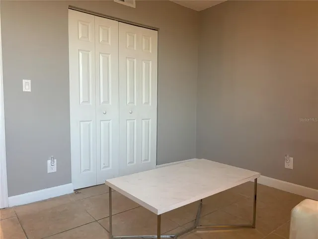 an empty room with windows and closet area