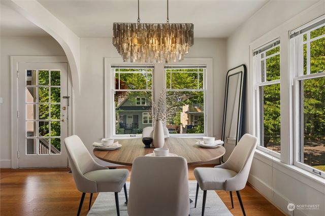 a dining room with furniture a chandelier and wooden floor