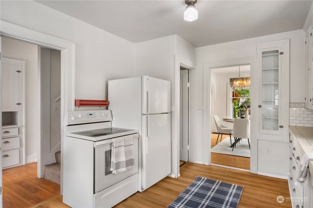 a kitchen with a refrigerator and white cabinets
