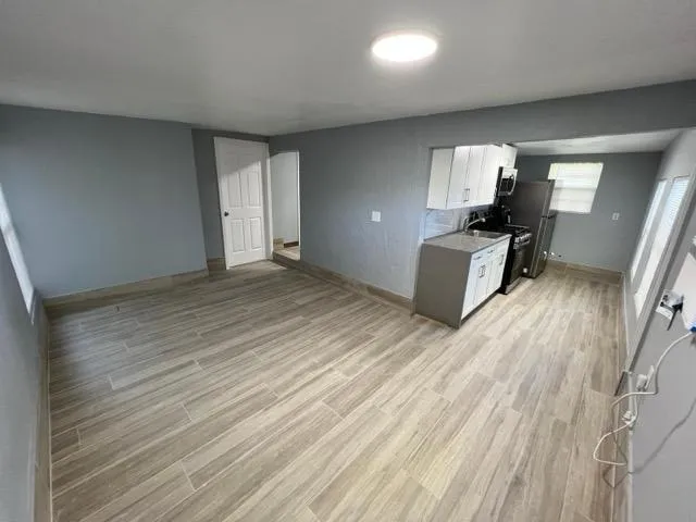 an empty room with wooden floor and windows