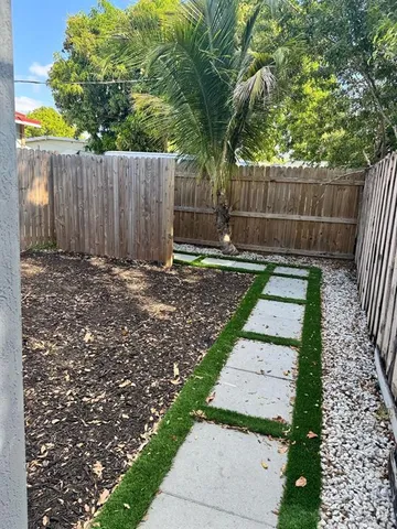 a view of a backyard with wooden fence