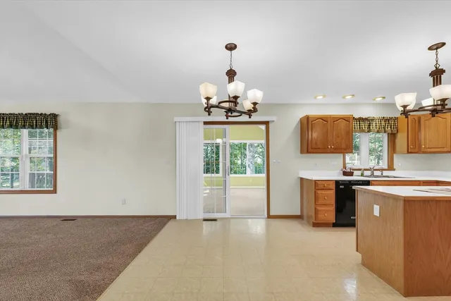 a kitchen with granite countertop a sink and a white wooden cabinets