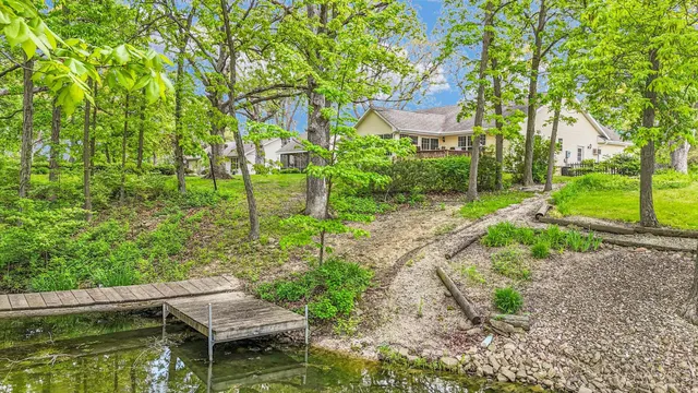 a front view of a house with a garden and trees