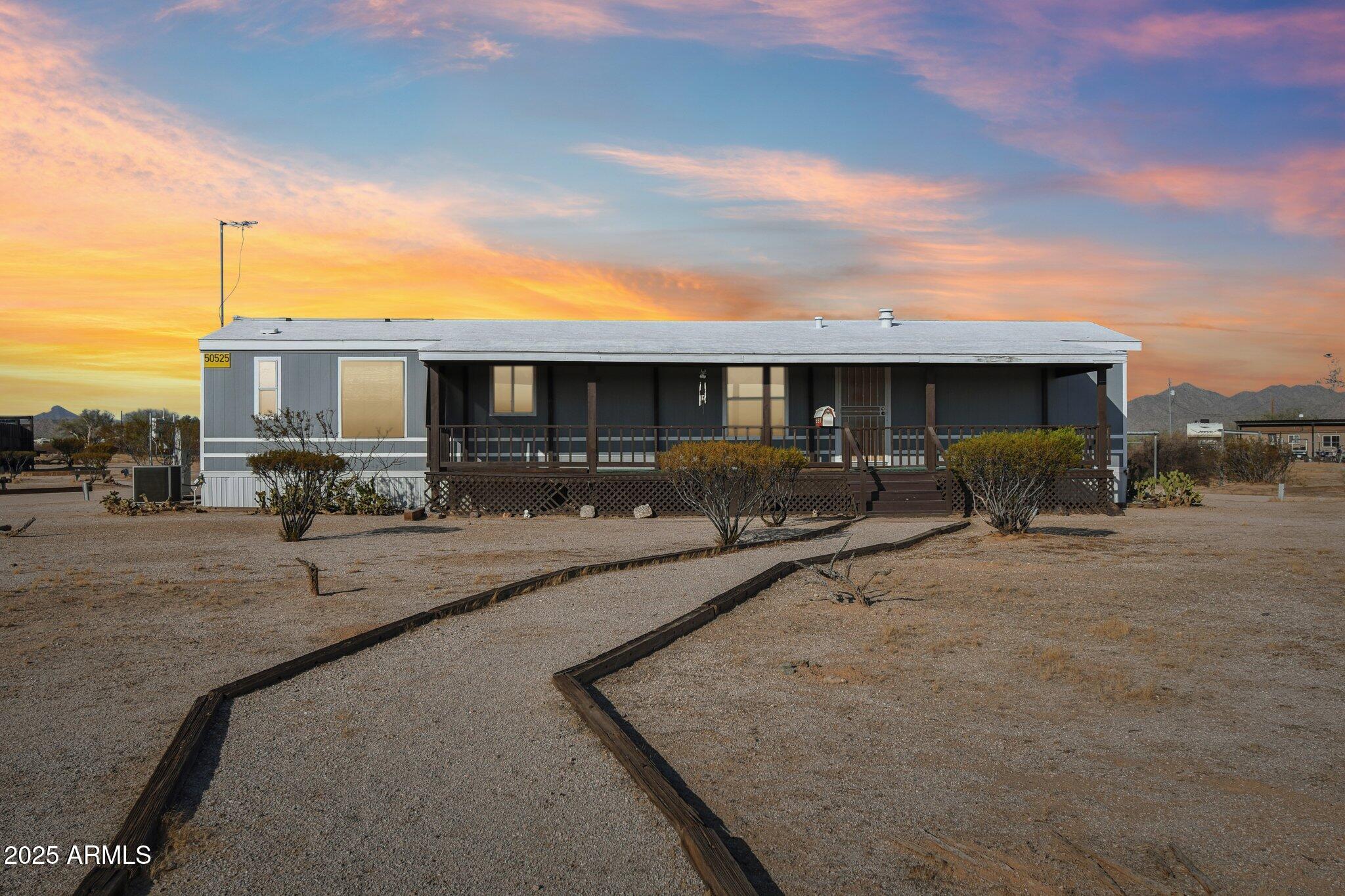 a view of a patio with couches and table and chairs under an umbrella