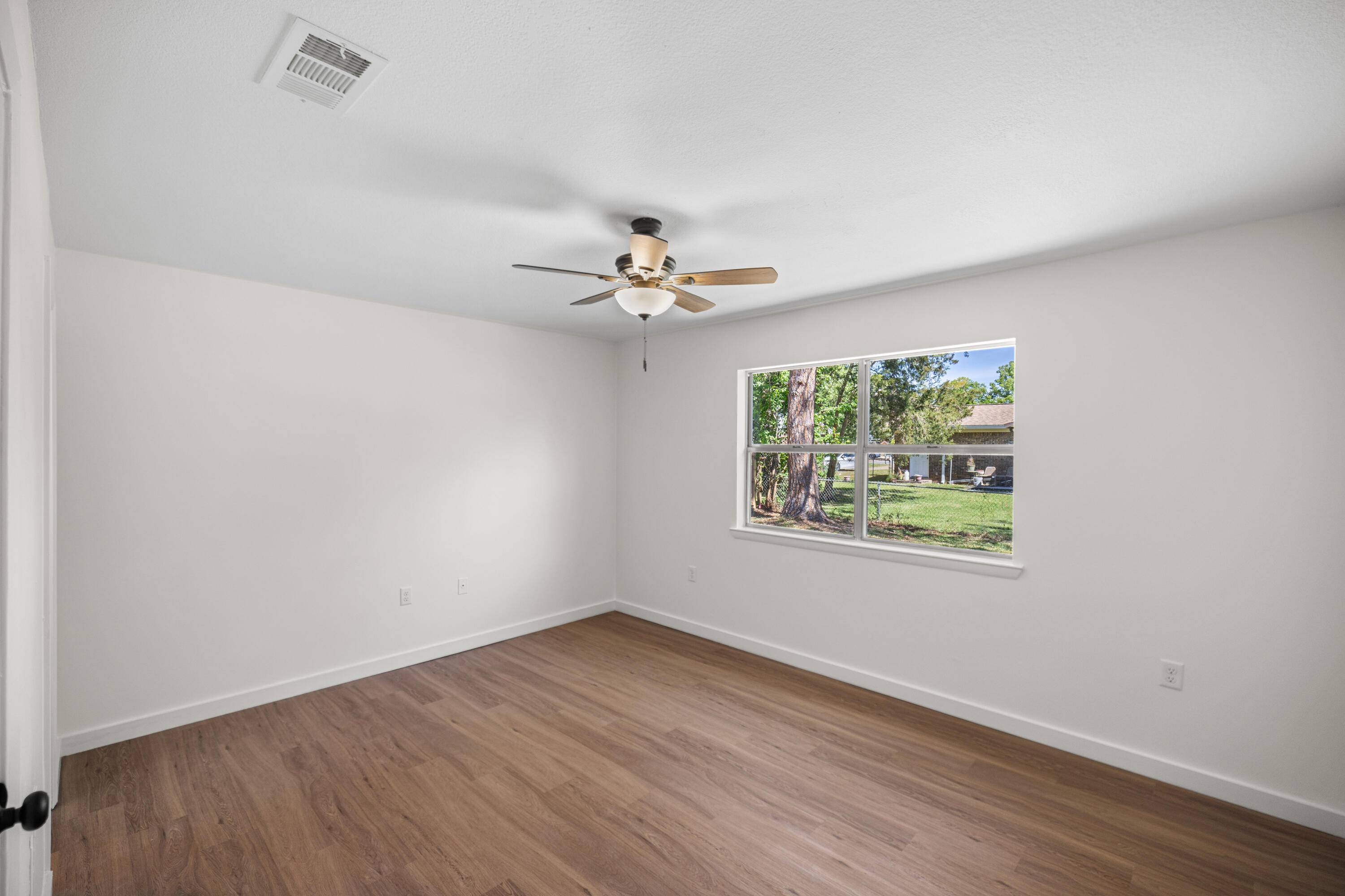 103 Perdido Circle Niceville, FL 32578 - Photo 12 of 71 wooden floor in an empty room with a window