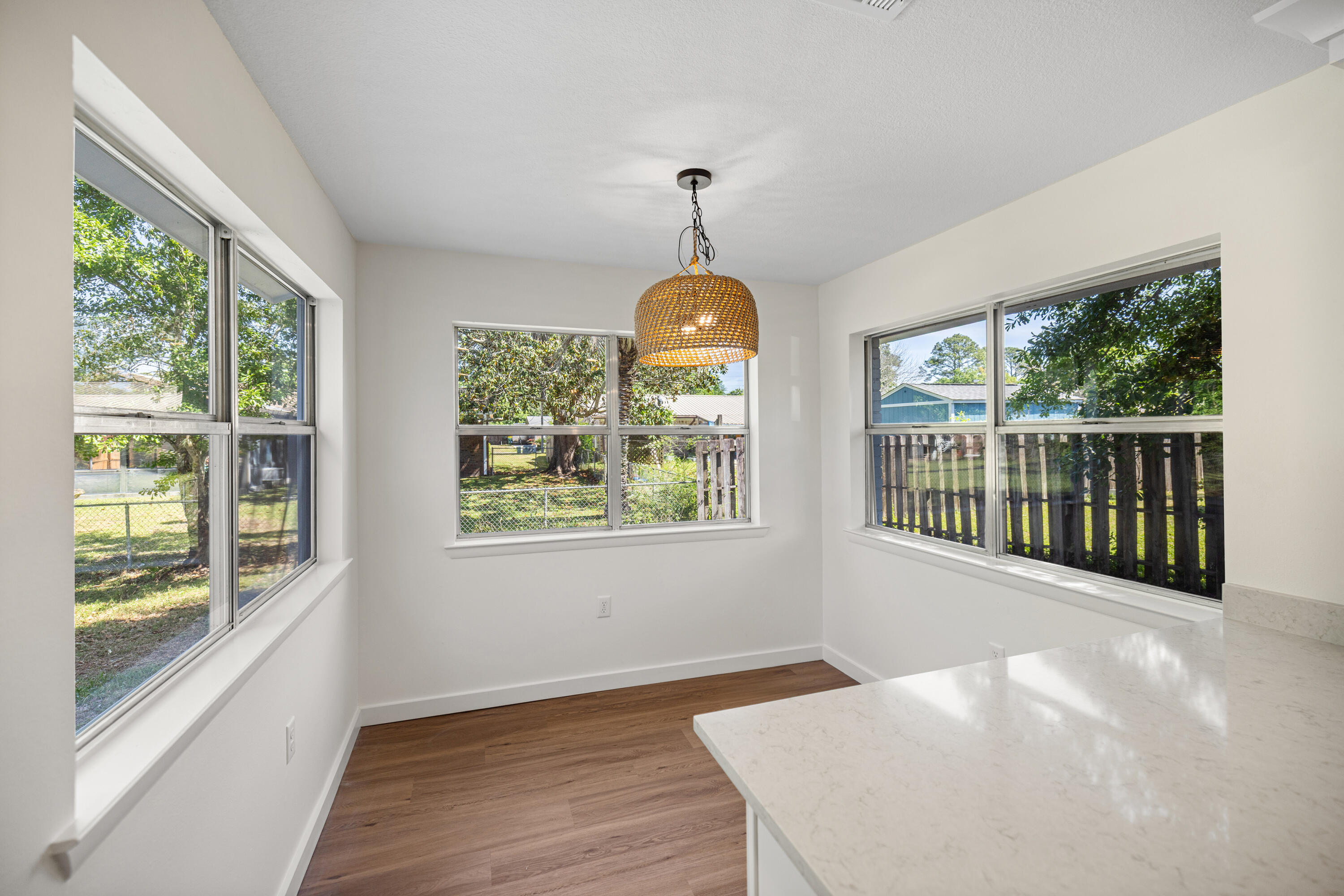103 Perdido Circle Niceville, FL 32578 - Photo 35 of 71 a view of a room with wooden floor a chandelier and windows