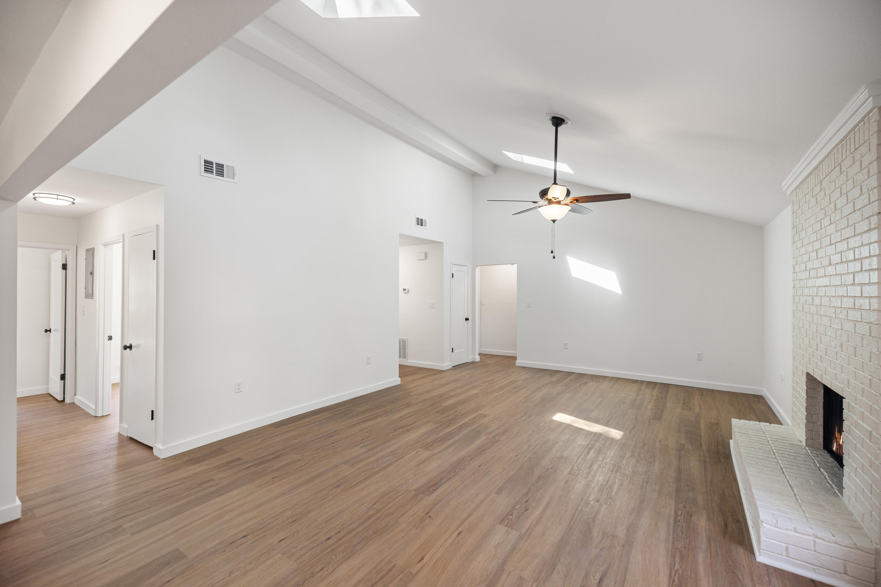 103 Perdido Circle Niceville, FL 32578 - Photo 9 of 71 an empty room with wooden floor chandelier fan and windows