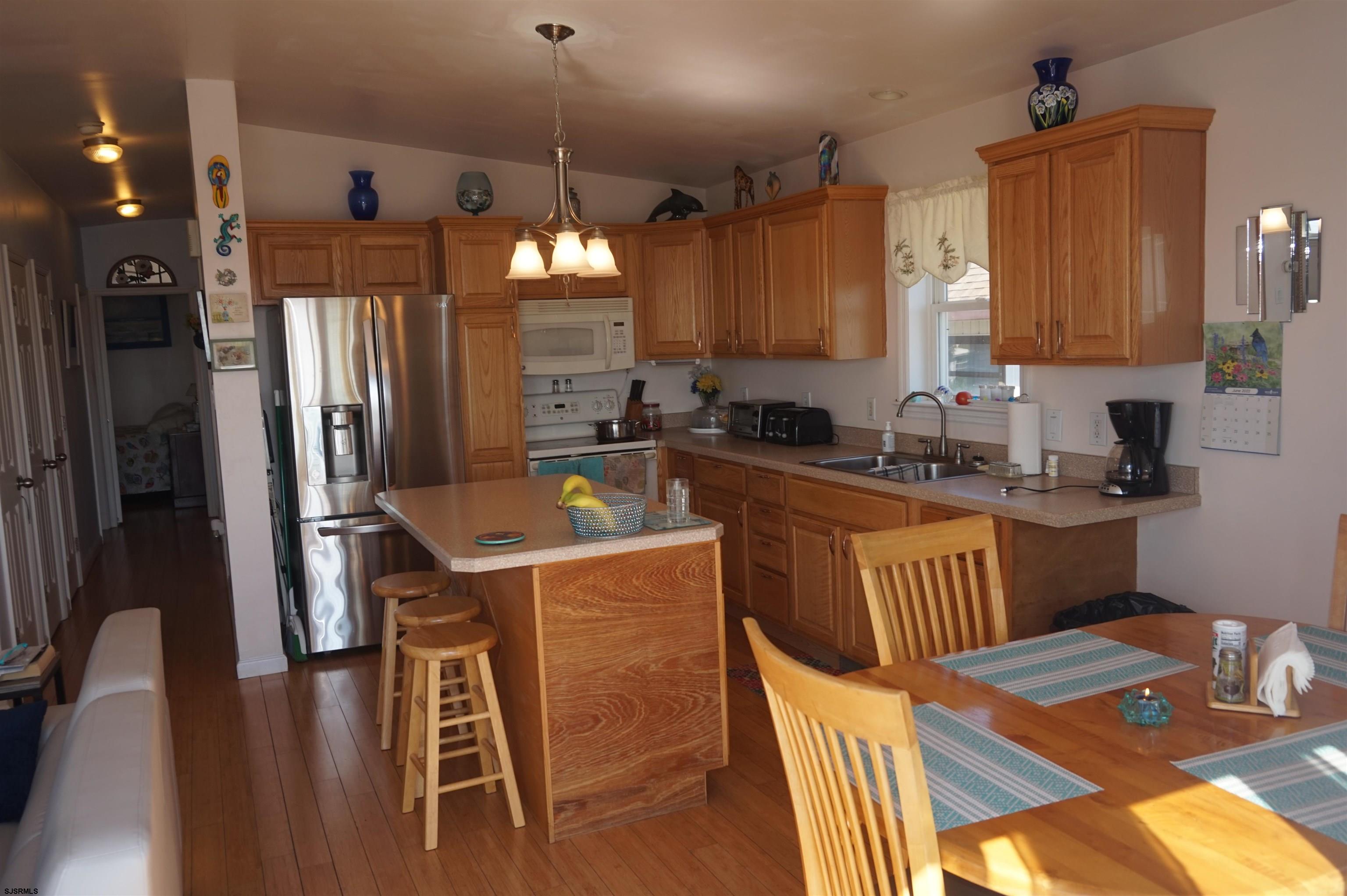 77 Delaware Avenue Fortescue, NJ 08321 - Photo 17 of 47 a kitchen that has a lot of cabinets a sink and a wooden floor