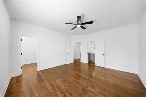 a view of a hallway with wooden floor and staircase